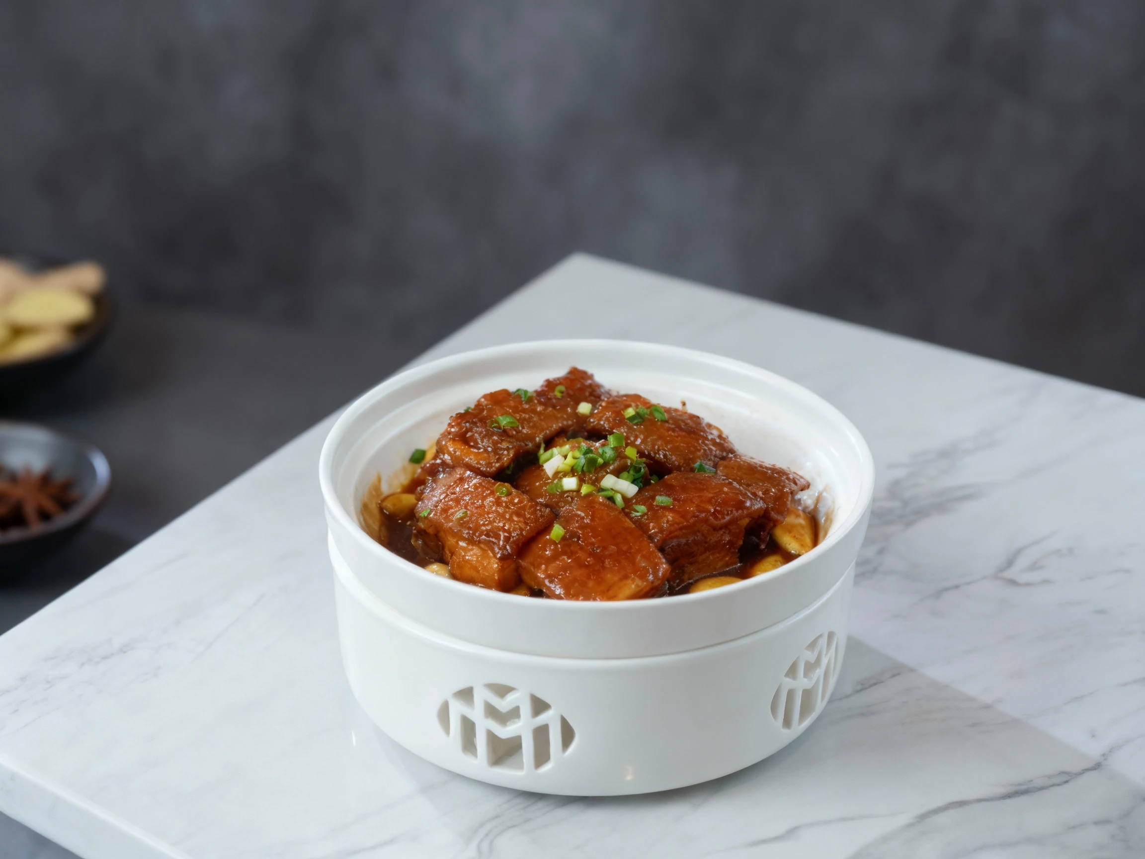 Braised pork belly cubes in a thick glaze garnished with chopped scallions and served over whole garlic cloves.