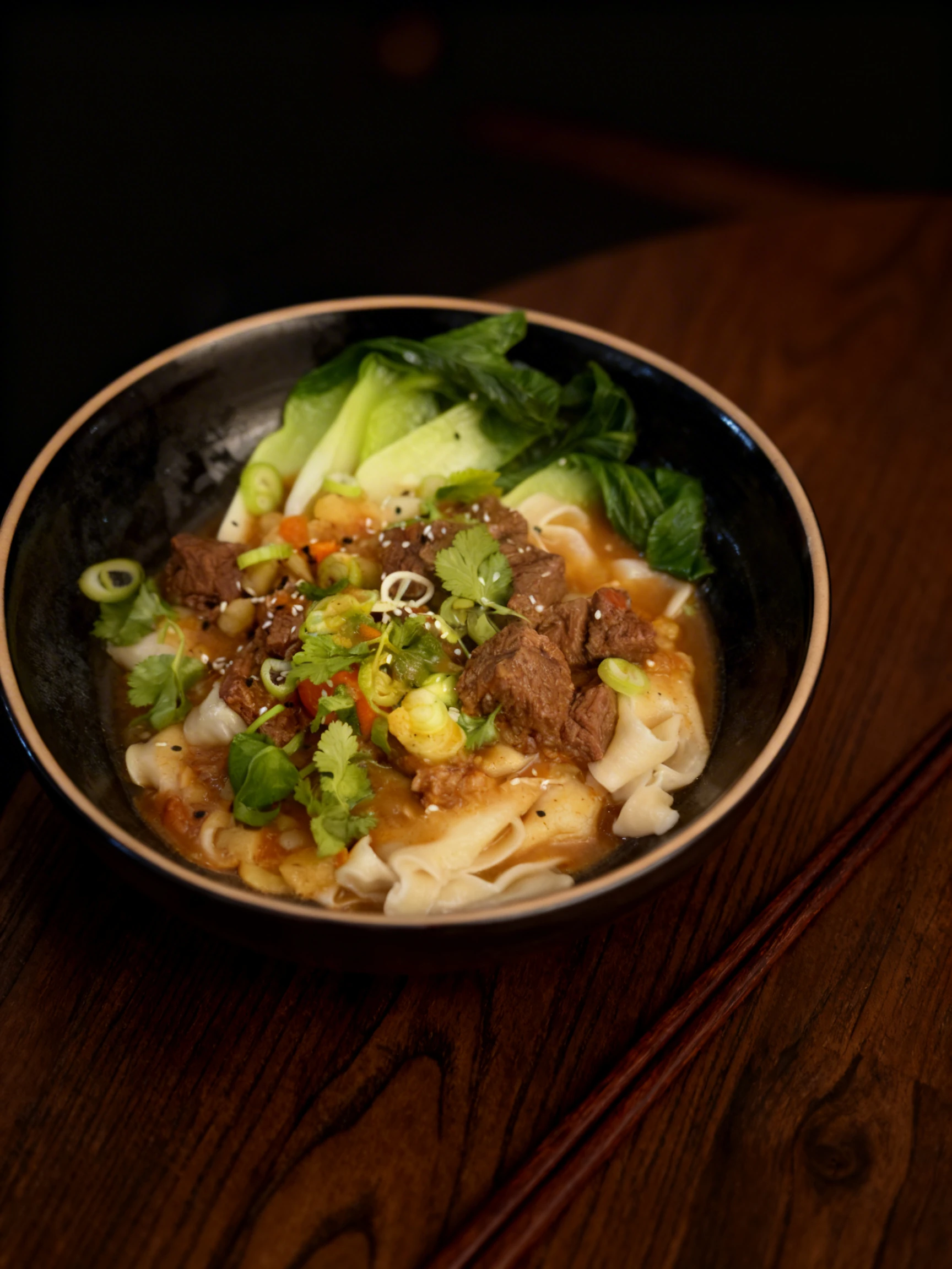 Braised beef noodle soup featuring wide wheat noodles, tender beef chunks, and bok choy garnished with spring onions, cilantro, and sesame seeds.