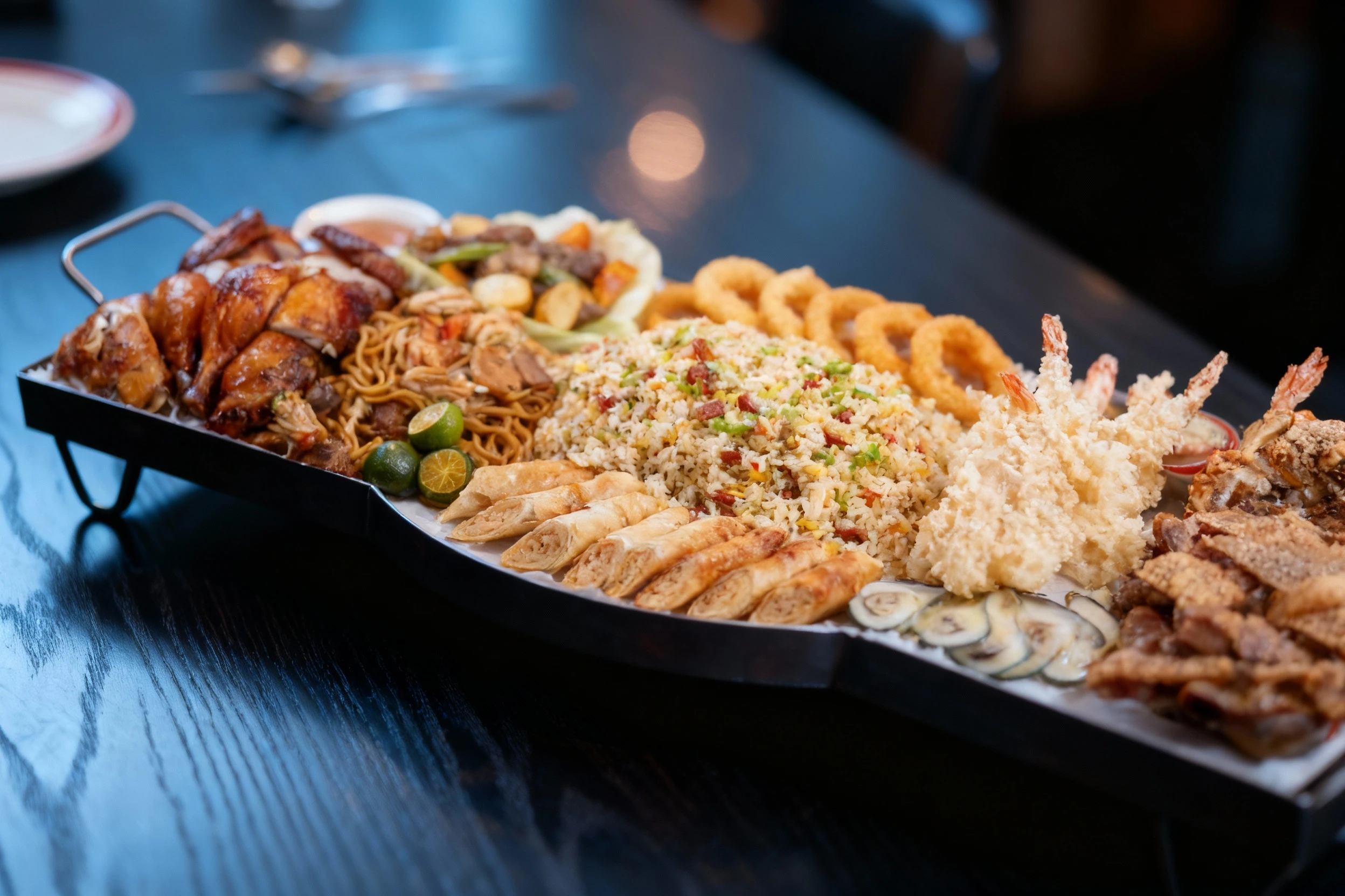 This elaborate platter features a variety of proteins including whole roasted chicken pieces, crispy pork pieces, and tempura shrimp, alongside a generous mound