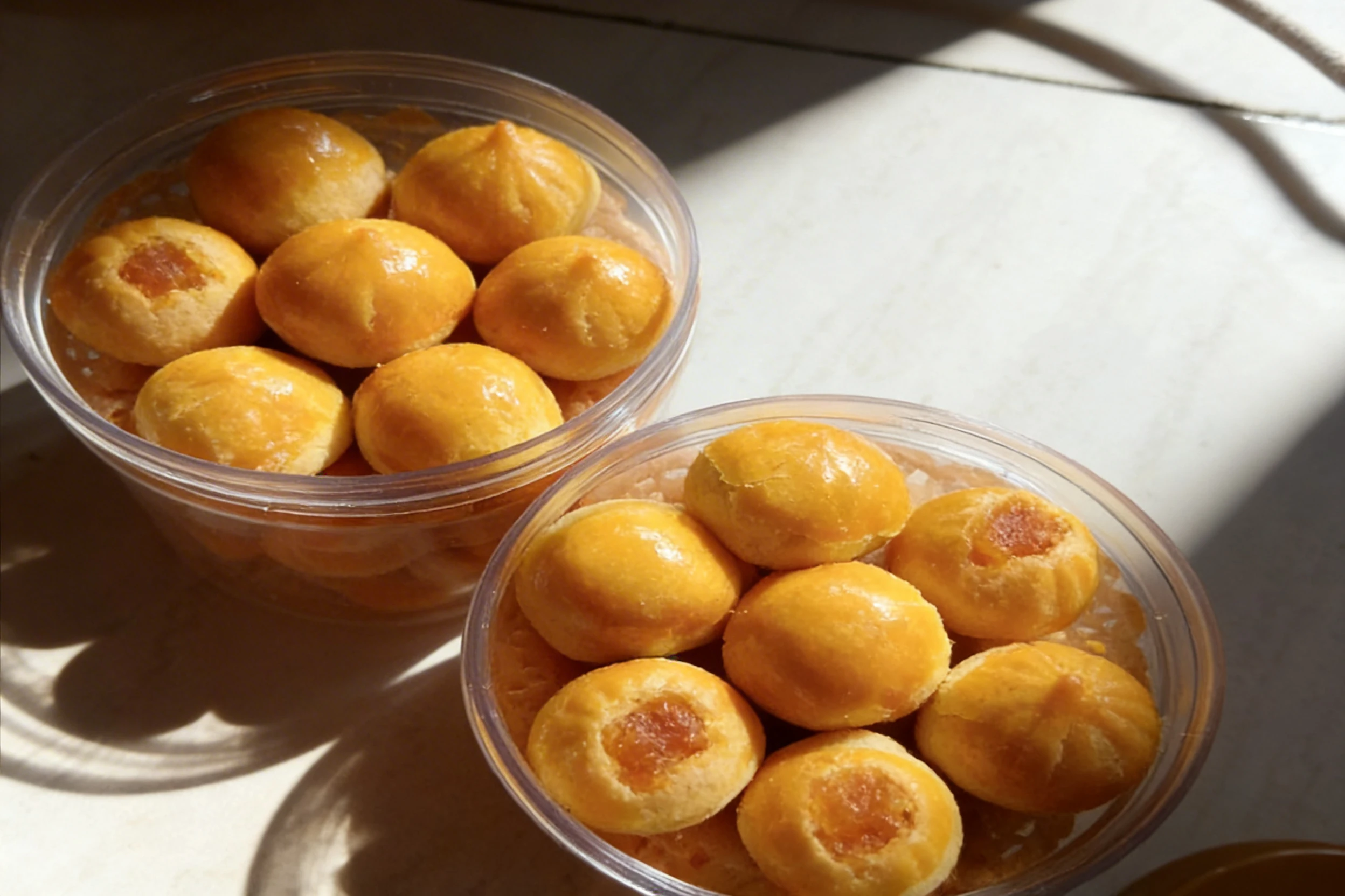 Nastar cookies, also known as pineapple tarts, featured as glazed golden spheres with a fruit filling.