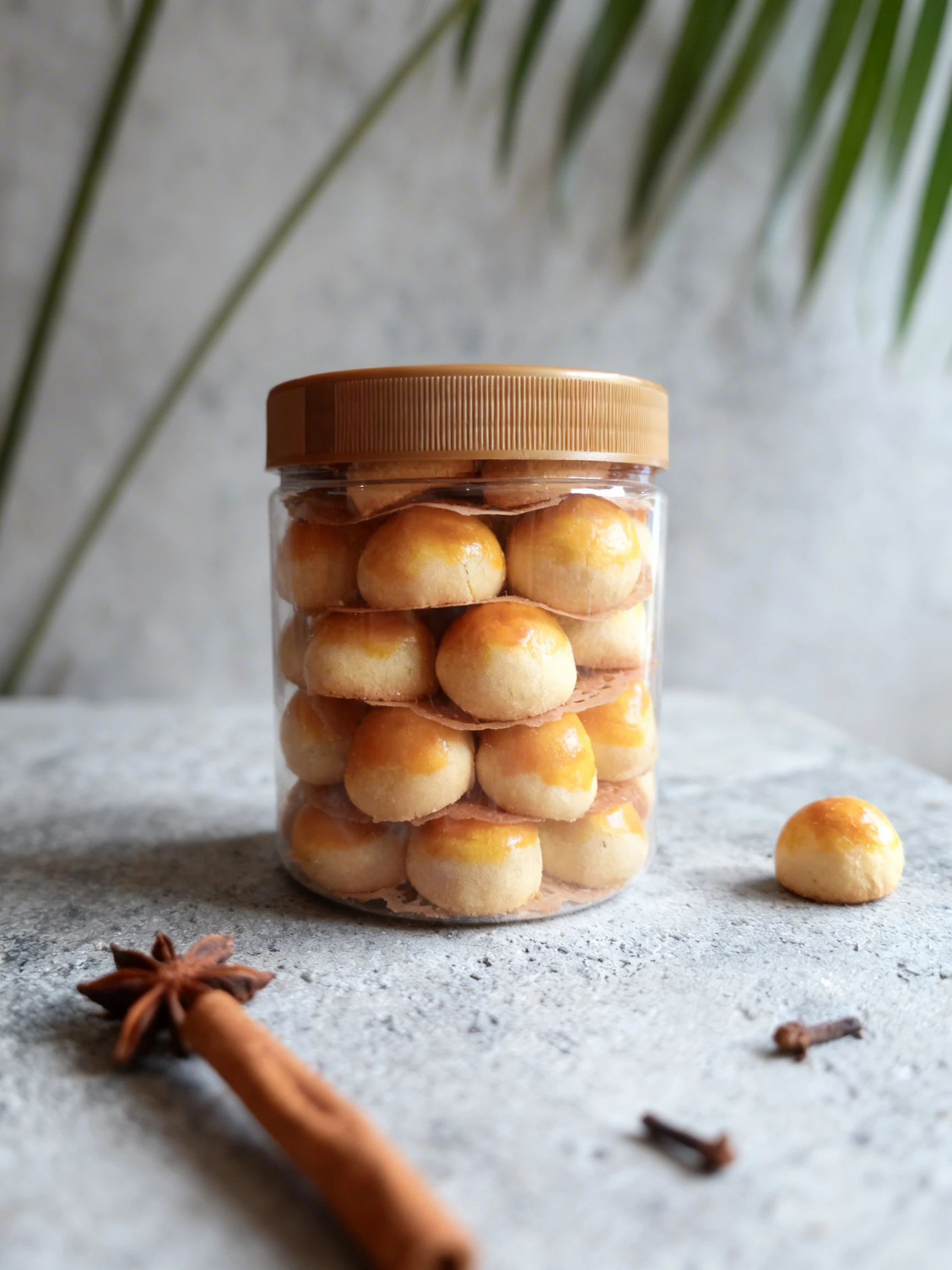 A plastic jar filled with Nastar pineapple tart cookies featuring an egg-washed glaze.