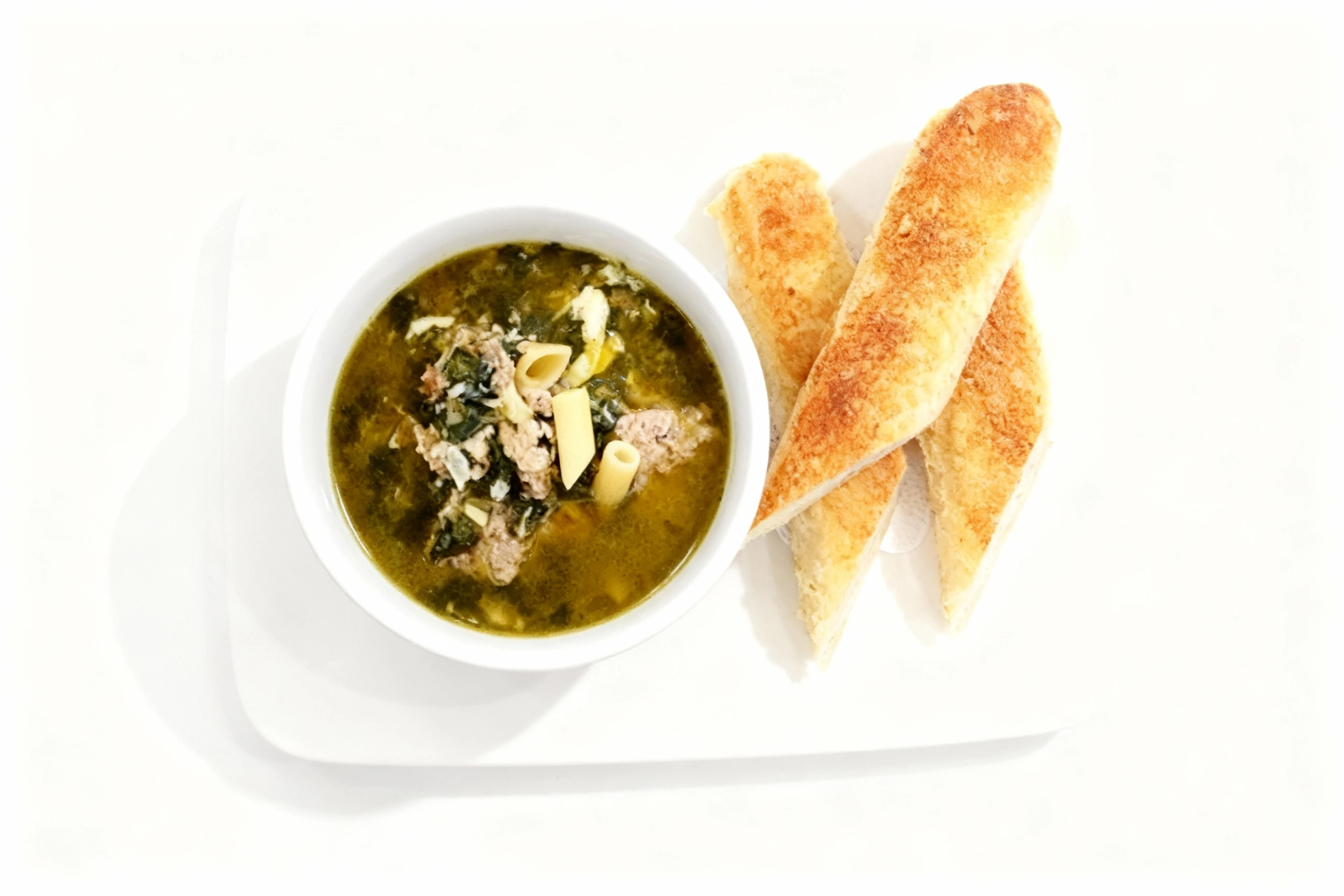 A bowl of Italian wedding soup containing penne pasta, crumbled sausage, and spinach, served alongside three slices of toasted baguette.