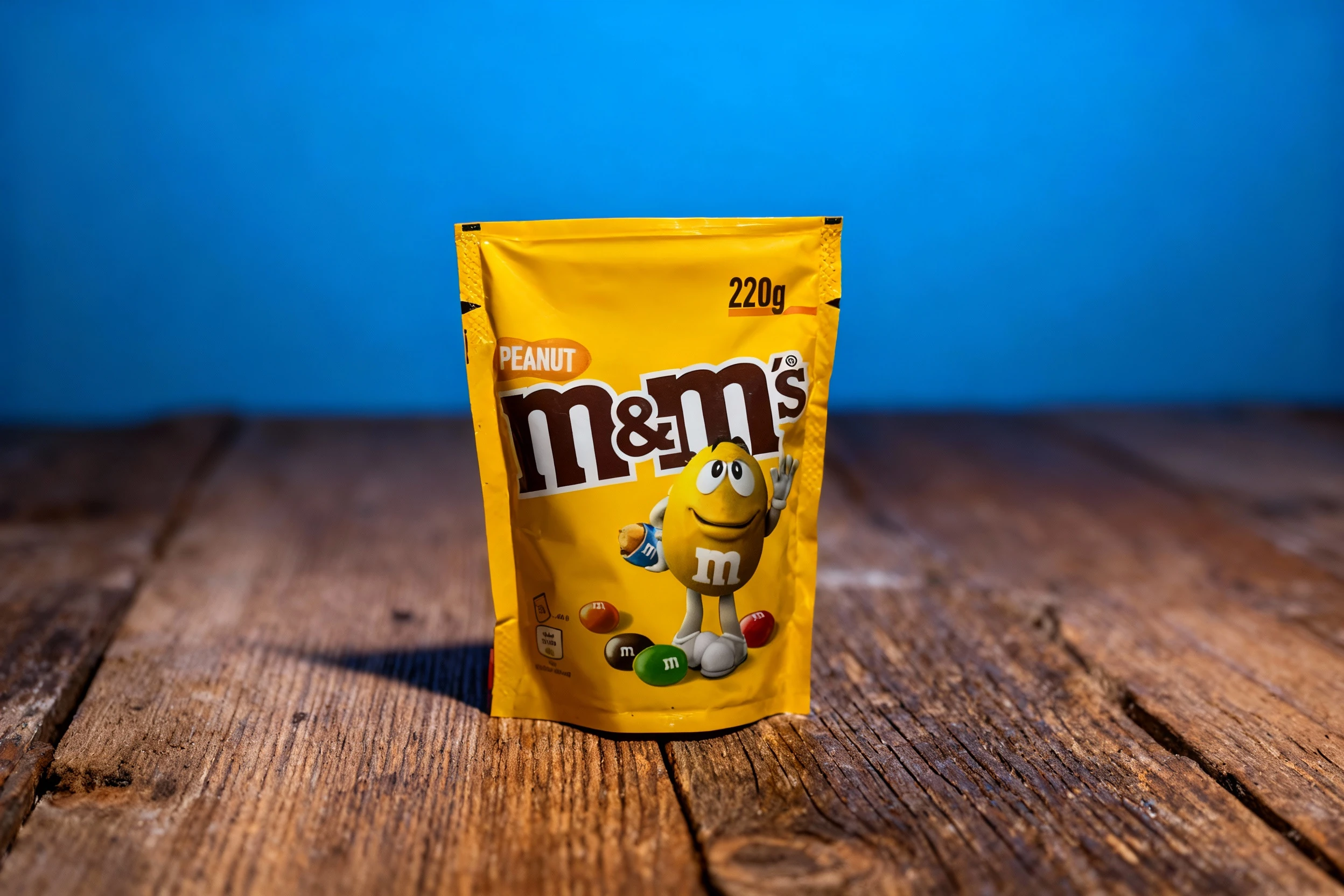 A 220g stand-up pouch of Peanut M&M's, a confection consisting of peanuts covered in milk chocolate and a colorful candy shell.