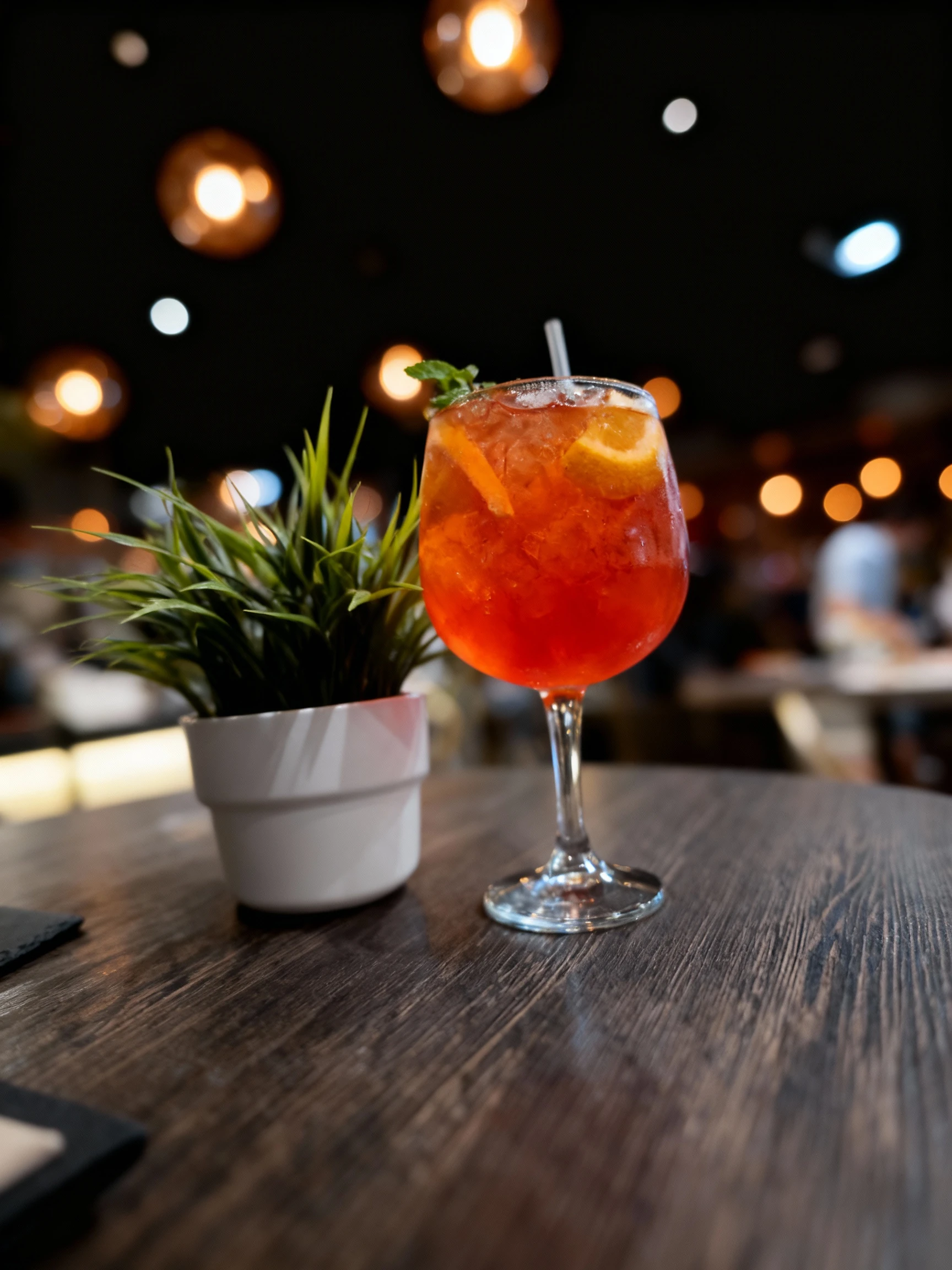 An Aperol Spritz cocktail served in a large wine glass with ice, an orange slice garnish, and fresh mint leaves.