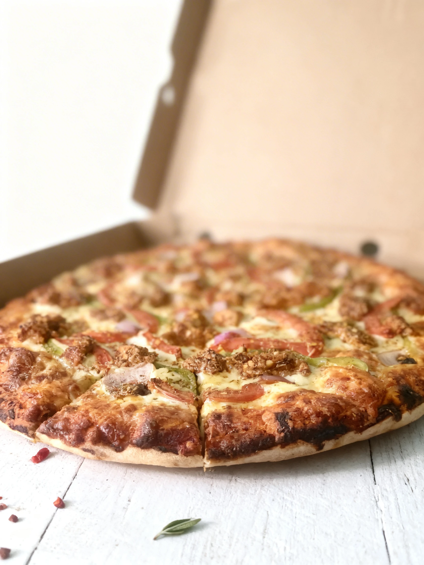 A whole pizza topped with melted mozzarella cheese, seasoned chicken chunks, sliced tomatoes, green peppers, and red onions.